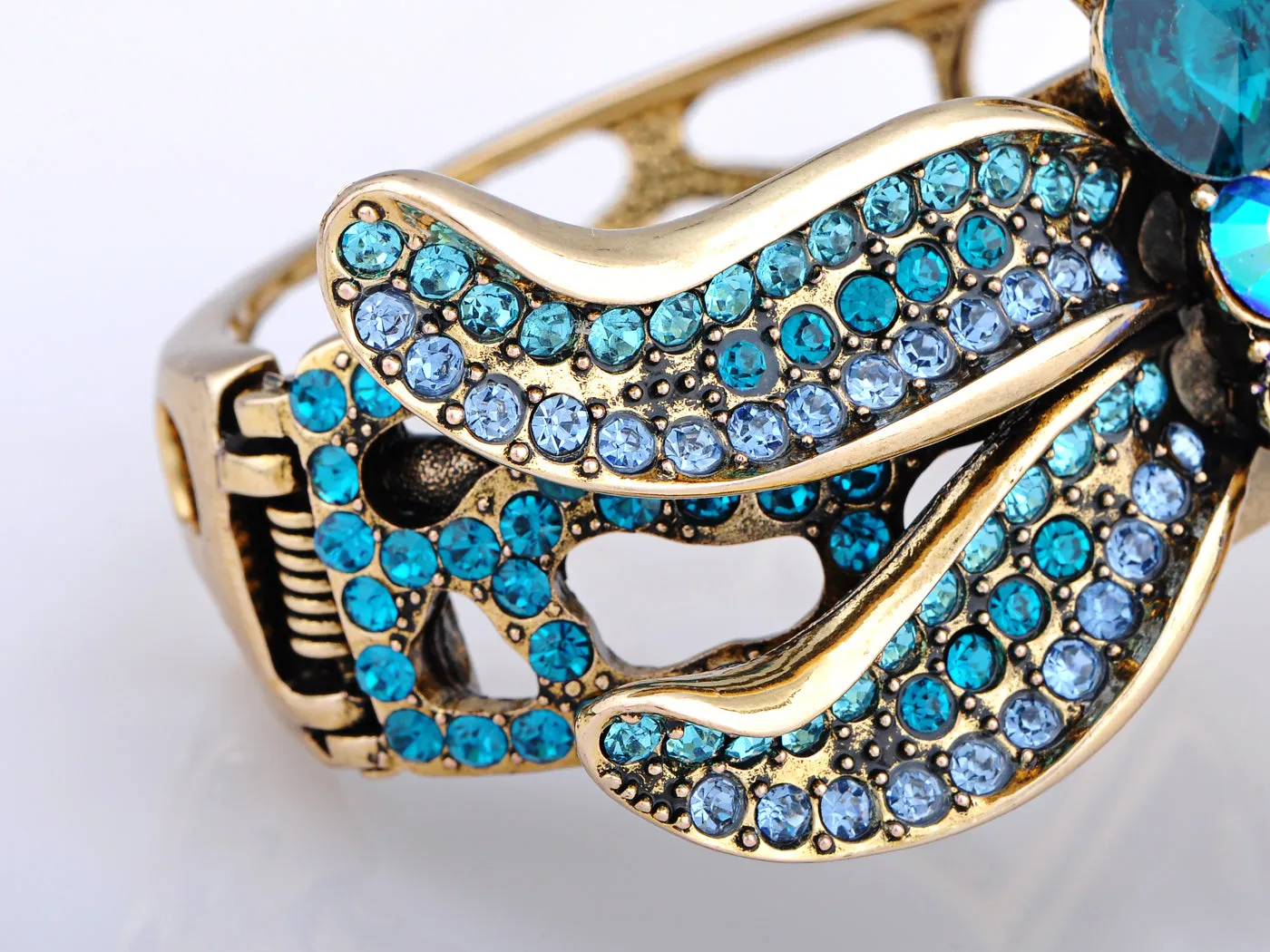 Electrifying Blue Zircon Dragonfly Over A Gold Cuff Bracelet